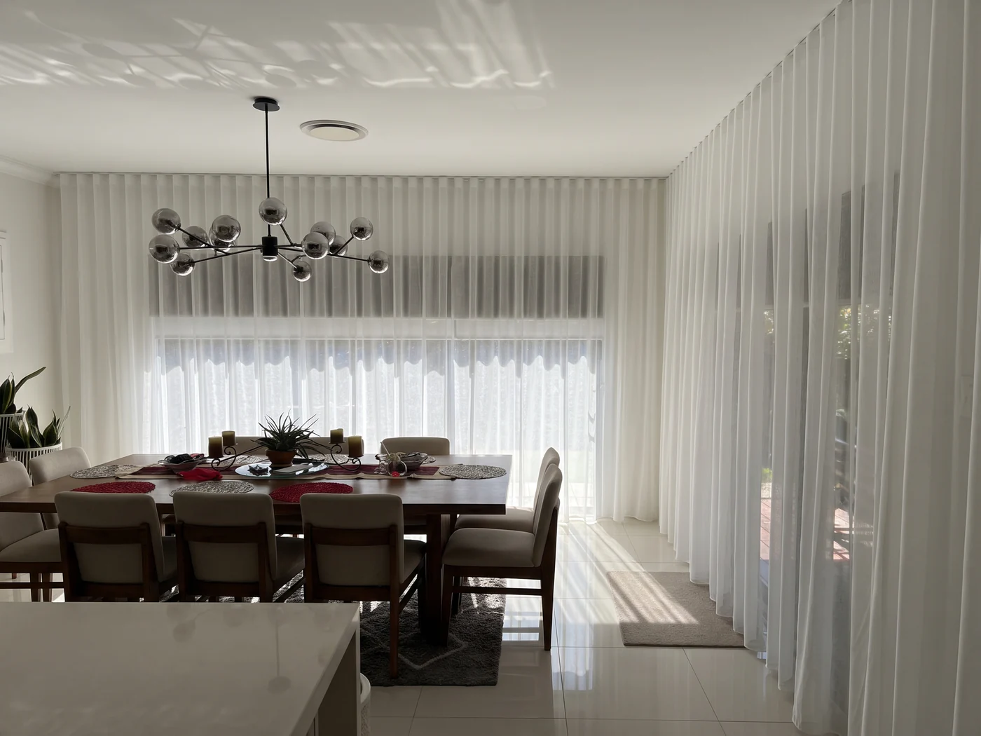 A Sydney dining room with sheer curtains &mdash; soft filtered daylight with the garden still visible